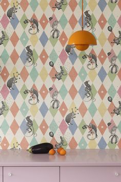 a kitchen with colorful wallpaper and an orange lamp