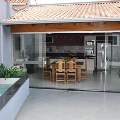 a kitchen and dining room with glass doors leading to an outside patio area that has a pool in the middle