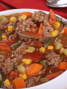 a spoon full of soup with meat and vegetables