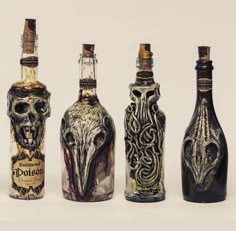 four bottles with different designs on them sitting next to each other