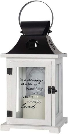 a small white lantern with a quote on the front and bottom panel in black ink