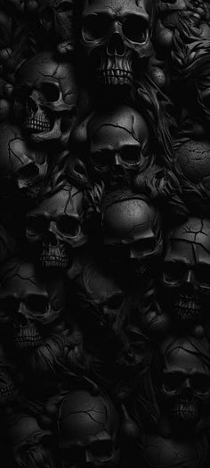 black and white photograph of skulls with long hair on their heads, in the dark