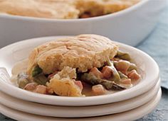 there is a white plate with a chicken pot pie on it and another dish in the background