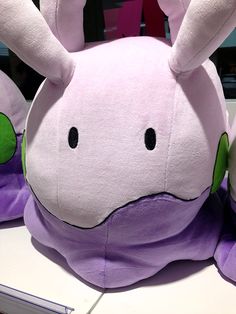 a purple stuffed animal sitting on top of a desk