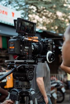 a camera set up on a tripod in front of a man walking down the street