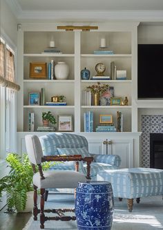 a living room filled with lots of furniture and a flat screen tv mounted to the wall