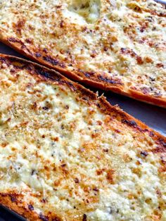 two slices of cheese pizza sitting on top of a metal pan covered in melted cheese