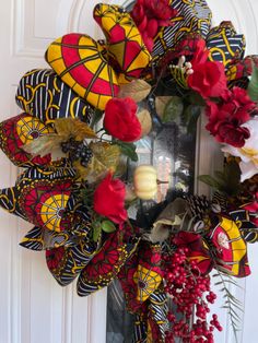 a yellow and red wreath with flowers on the front door, decorated with butterfly wings