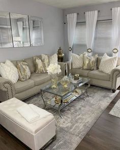 a living room filled with lots of furniture and pillows on top of a wooden floor