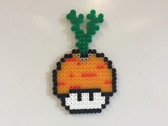 an ornament made to look like a pixel head with green leaves on it