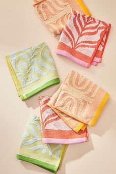 four towels folded on top of each other in different colors and patterns, with the word love printed on them