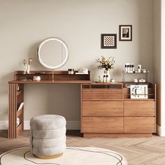 a desk with a mirror, stool and pictures on the wall in a living room