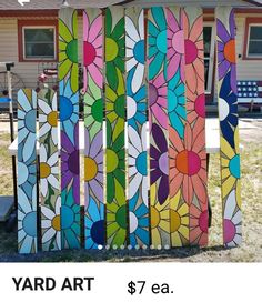 the yard art $ 7 eaa is on display in front of a house with flowers painted on it