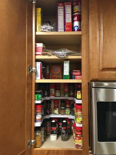 an open cabinet with spices and condiments in it