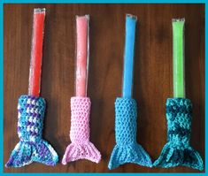 three crocheted candles are lined up in different colors and sizes, one is pink, the other is blue