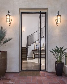 an entry way with potted plants and stairs