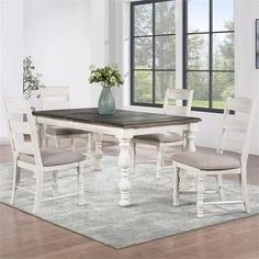 a dining room table and chairs in front of a window with a rug on the floor