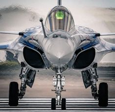 a jet fighter sitting on top of an airport runway