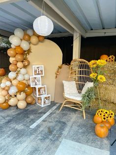 an outdoor area with hay bales and pumpkins