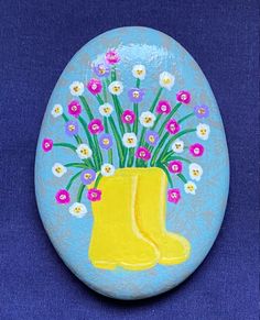 a painted yellow boot with flowers in it on a blue background is the symbol of spring