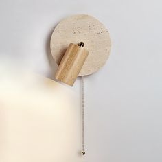 a wooden clock hanging from the side of a wall with a chain attached to it