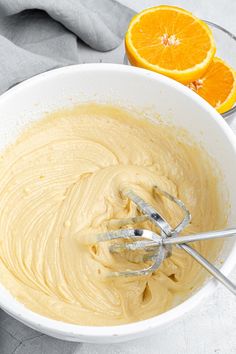 a bowl filled with batter next to an orange