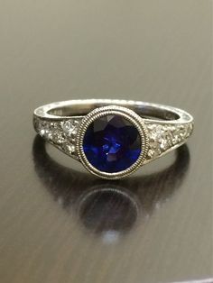 DeKara Designs Collection An Art Deco Platinum Ceylon Blue Sapphire breathtaking ring that must be seen in person to be appreciated.  Metal- 90% Platinum, 10% Iridium.Stones- 1 Round Ceylon Blue Sapphire, 1.83 Carats.  10 Round Diamonds, G color VS1 clarity, 0.36 Carats.  The craftsmanship on this ring is impeccable, and will look extraordinary on a true art lovers finger.  You will wear this ring with great joy, and love.  You will keep glancing at it because it will distract you so much!  Plea Classic Sapphire Diamond Ring Gia Certified, Classic Gia Certified Sapphire Ring, Classic Sapphire Rings In Platinum, Classic Sapphire Rings With Brilliant Cut, Gia Certified Sapphire Diamond Ring In Timeless Style, Classic Sapphire Jewelry Gia Certified, Gia Certified Timeless Sapphire Diamond Ring, Classic Gia Certified Sapphire Jewelry, Classic Sapphire-colored Diamond Ring With Center Stone