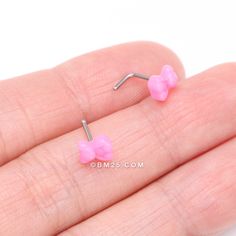 small pink bowknot earrings on finger