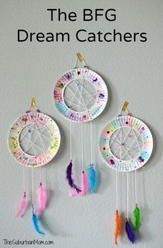 paper plate dream catchers with colorful feathers hanging from the ceiling and text overlay that says, the b fg dream catchers