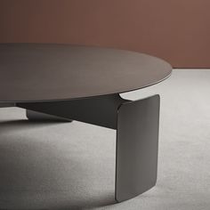 a round table sitting on top of a carpeted floor next to a brown wall