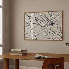 a wooden table sitting in front of a window next to a book on top of a hard wood floor