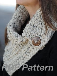 a close up of a woman wearing a knitted cowl with buttons on it