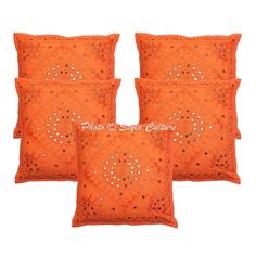 four orange pillows with decorative designs on them