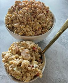 two bowls filled with macaroni salad on top of a table