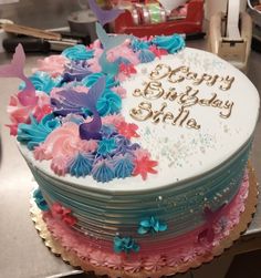 a birthday cake with butterflies on it sitting on a table in front of other items