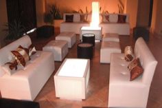 a living room filled with lots of white couches and chairs next to each other