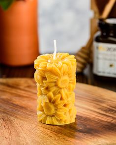 a candle that is made out of pasta on a wooden table next to a potted plant