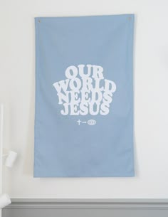 a blue wall hanging with the words our world needs jesus printed on it in white