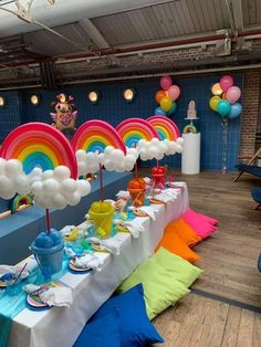 a table set up for a rainbow themed birthday party