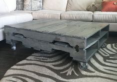 a living room with a zebra print rug and white couch in the background, including a coffee table made from an old pallet