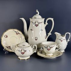 a white tea set with matching saucers and cups on a blue background, in the style of china