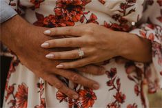 a close up of two people holding each other's hands with their wedding rings