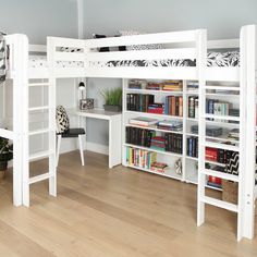 a white bunk bed sitting next to a desk and bookshelf