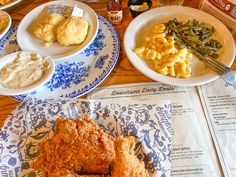 fried chicken, green beans and mashed potatoes on a blue and white plate next to a newspaper