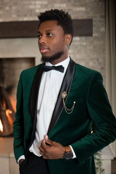 a man in a tuxedo standing next to a fireplace