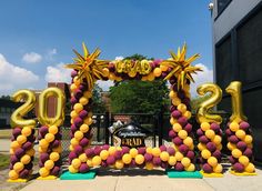 an arch made out of balloons with the number 2012 spelled out in gold and purple