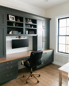 a home office with gray cabinets and black leather chair