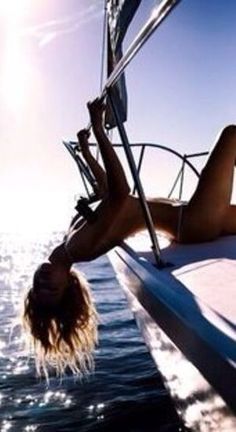 a woman laying down on the back of a boat