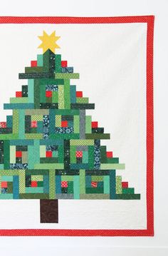 a quilted christmas tree hanging on the wall