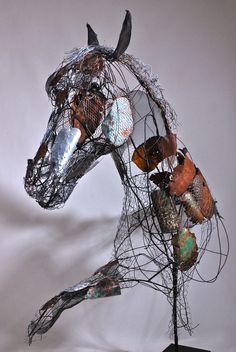 a wire horse sculpture with many different colored items on it's head